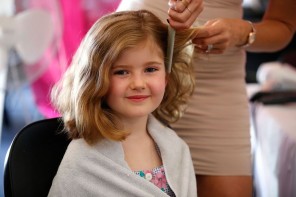 A festival participant enjoys having her hair done.